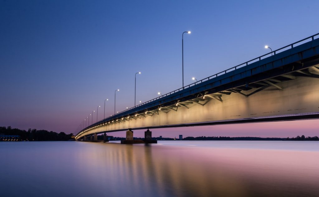 gray concrete bridge with body of water during nighttime